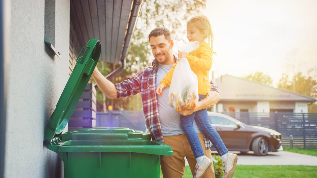 man showing daughter how to manage waste with recycling for the simpler recycling legislation
